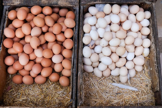 Brown and white eggs in rustic wooden crates