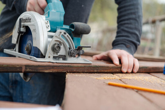 Makita Circular saw, tool brand, authentic outdoor setting, using the tool, tool that has been used.