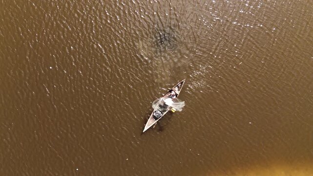 Aerial top view of a traditional fisherman in a wooden boat with his catch in Luanda, Angola