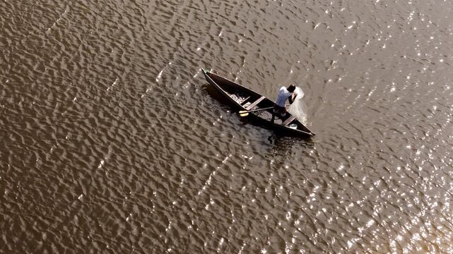 Aerial top view of a traditional fisherman in a wooden boat with his catch in Luanda, Angola