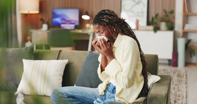 Sick, sneeze and black woman with tissue on sofa, flu season or chronic sinusitis for health crisis. Blowing nose, allergies or person with illness in home for recovery, hay fever or viral infection