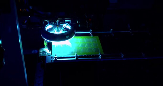 High-resolution footage of a modern high-tech automated machine assembling an electronic printed circuit board with high precision.