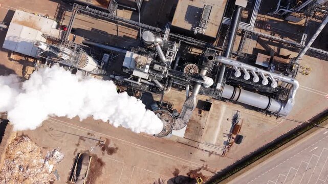 Factory Skyline With Smoke Clouds. Paper Manufacturing Site With Steam Emissions Visible. Aerial Perspective Of Polish Paper Mill With Steam Plumes Rising Above Storage Areas