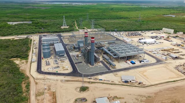 Manzanillo Power Land In Dominican Republic - Industrial Power Plant With Smokestacks And Cooling Array. aerial arc shot