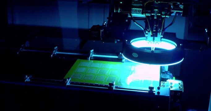Modern high-tech production: Close-up of an automated high-precision machine assembling an electronic printed circuit board.