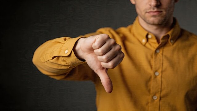 Businessman giving a thumbs down gesture with negative expression disapproval concept rejecting an idea dissatisfaction bad feedback saying no failure losing confidence against
