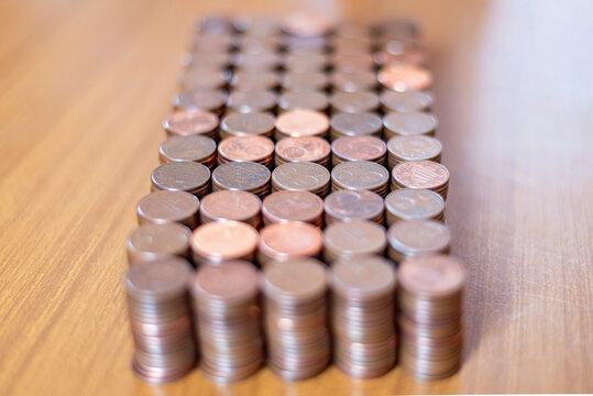 Pile di monete di rame ordinate su tavolo di legno