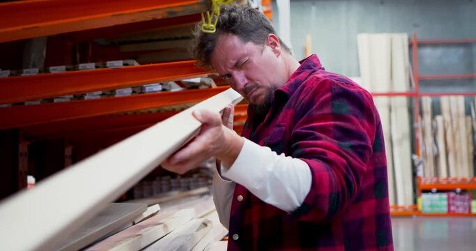 Man Selecting Lumber in a Warehouse Store