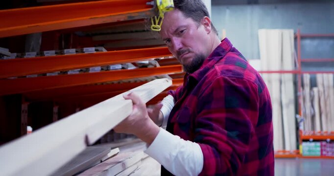 Man Selecting Lumber in a Warehouse Store
