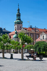 Obraz premium Summer day, Market Square (Rynek). In background rises the tower of Evangelical Church of Augsburg Confession (kościół Ewangelicko-Augsburski). Pszczyna, Poland. 