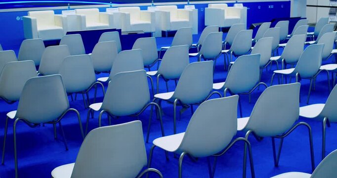 Empty modern conference hall with chairs arranged in a spacious bright room.