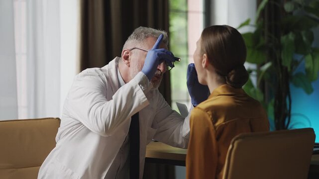 Male ENT doctor examining female patient's throat in hospital, health check-up