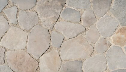Obraz premium Close-up view of an irregular natural stone wall or pathway with varying light grey and beige tones set in mortar.