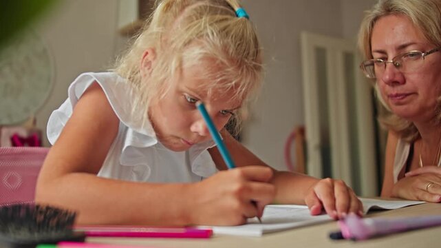 Mother assists her daughter during home study time. Preparing for school with focus on learning readiness and confidence