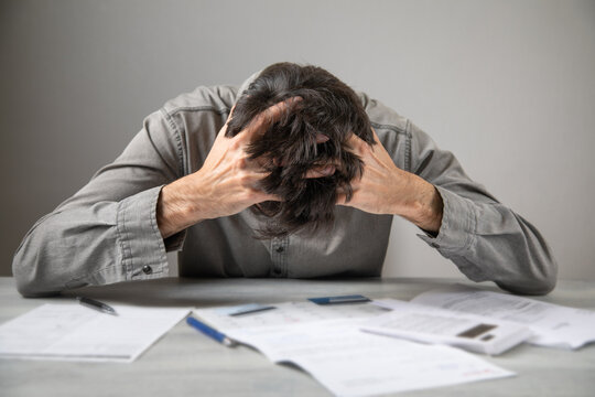 Bankrupt man with a financial documents. Debt