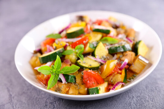 traditional french ratatouille with fresh basil, cooked mediterranean vegetables with zucchini eggplant and tomato, conceptual healthy vegan diet and organic lifestyle meal
