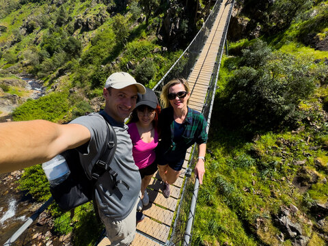 Photography, happy people or phone on outdoor bridge, social media post or update for profile picture. Fitness, below or friends with mobile app in nature, hiking break and pause together for bonding