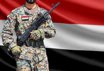 Fototapeta premium Yemen flag with soldier holding assault rifle