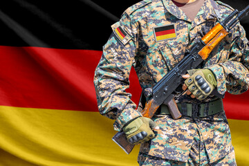 Naklejka premium Germany flag with soldier holding assault rifle