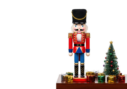 highly detailed wooden nutcracker figure in red military tunic, on a polished mahogany shelf with foil christmas gifts, isolated against bright white background, luxury holiday catalog concept