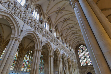 A grand cathedral interior with soaring vaulted ceilings, gothic arches, and massive columns, lit by stained glass windows in Beverley Minster - Yorkshire - Great Britain © Robert