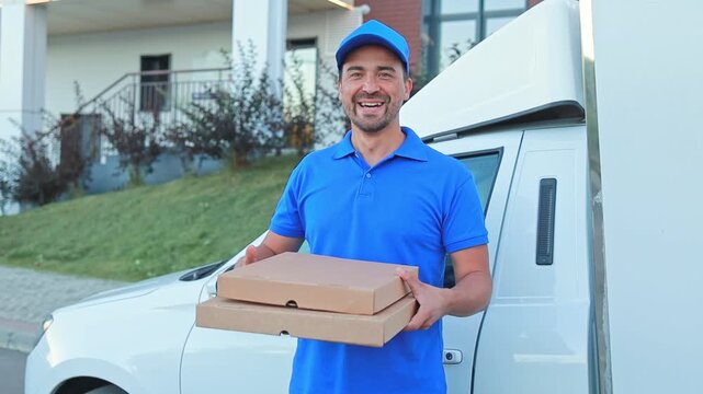 Male courier in blue uniform holding craft pizza boxes. Food delivery, online order, courier service. Pizzeria
