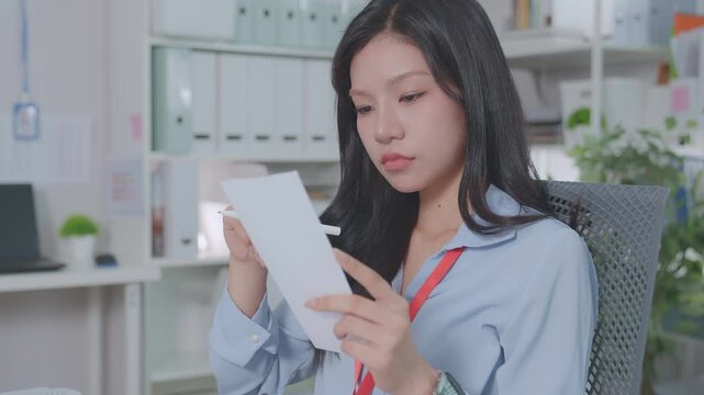 ฺBeautiful Asian accountant calculates financial expenses related to credit, budgets credit costs, records expenses or bills, reviews receipts, and plans tax assessments. Work actively.