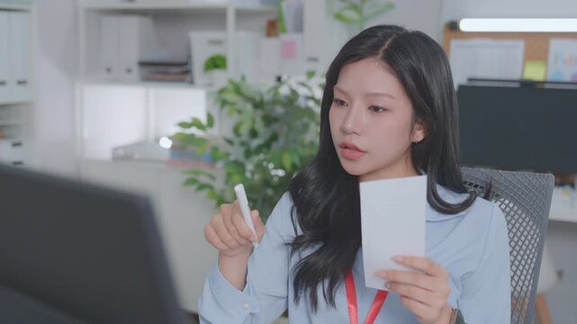 ฺBeautiful Asian accountant calculates financial expenses related to credit, budgets credit costs, records expenses or bills, reviews receipts, and plans tax assessments. Work actively.