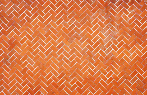 Orange brick wall with classic herringbone pattern for architectural design