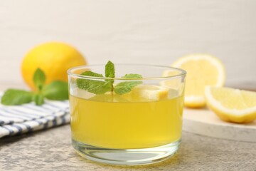 Fototapeta premium Tasty lemon jelly served with mint on light grey table, closeup
