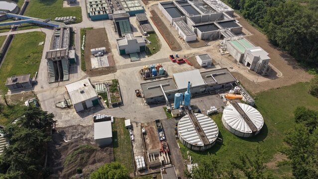 Industrial Water Treatment Plant: An aerial view of a sprawling industrial water treatment facility, showcasing complex infrastructure with tanks, pipes.