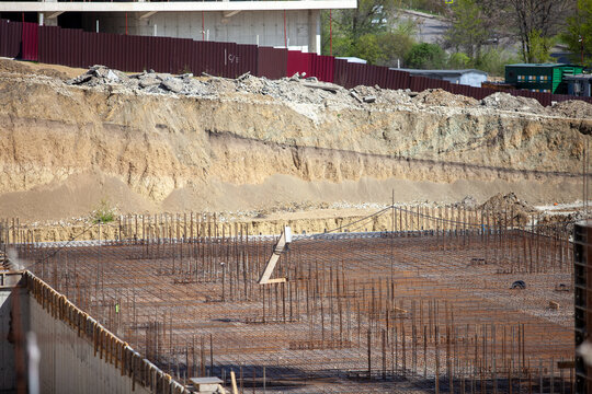 Row of adjustable steel shoring props supporting wooden beams for concrete slab formwork at a residential construction site.