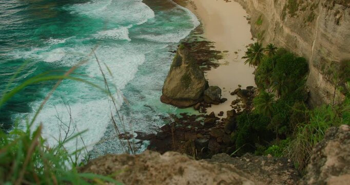 Steep cliff overlooks turquoise ocean waves at Diamond Beach in Nusa Penida Bali