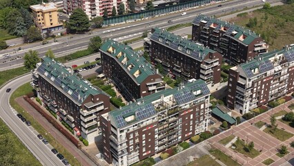 Modern Residential Buildings with Solar Panels: A high-angle view showcases several modern apartment buildings with distinctive green roofs and solar panels. © Andrew