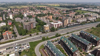 Fototapeta premium Urban Sprawl Vista: A sweeping aerial view captures the expansion of a suburban town, showcasing residential buildings, roadways, and distant fields.