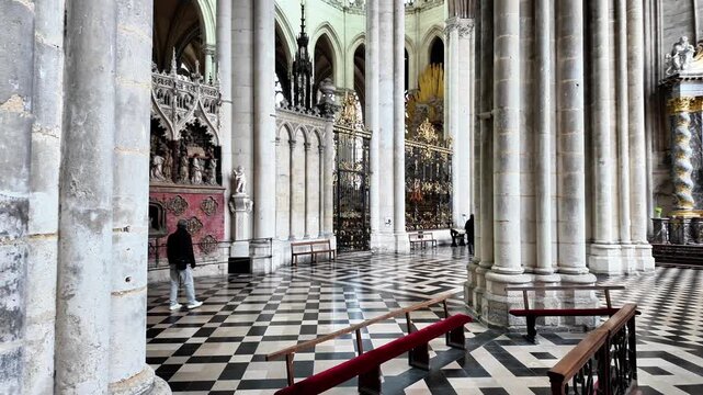 Low-angle tilt-up shot of the interior of a Gothic cathedral, from the patterned floor to the grand nave and altar.