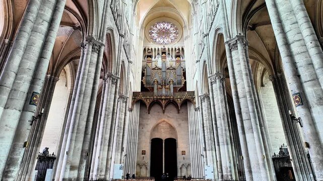 Low-angle tilt-up shot of the interior of a Gothic cathedral, from the patterned floor to the grand nave and altar.