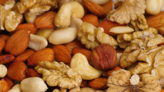 Close-up of mixed nuts including walnuts, almonds, cashews, and hazelnuts. Healthy assortment of various roasted and raw nuts for a nutritious snack