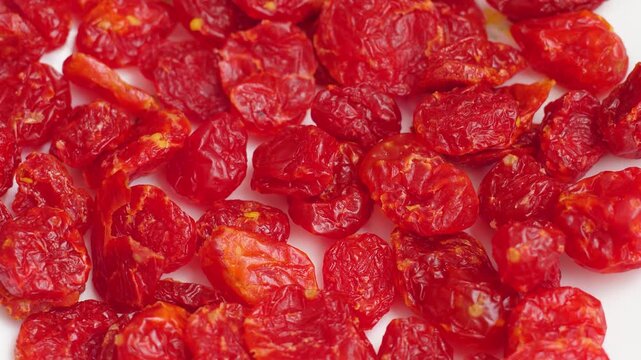Close-up of dried red cornelian cherries spread on a white background. Healthy dehydrated dogwood berries rich in antioxidants for a nutritious snack