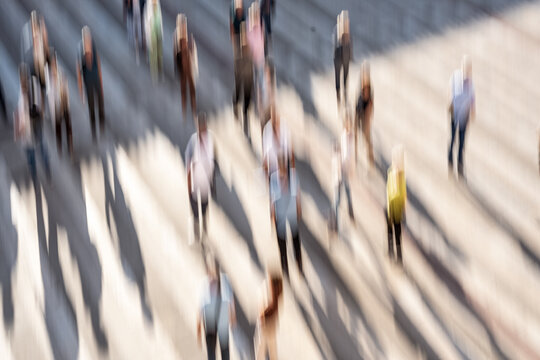 Group of people in motion in a city square, creative motion blur using intentional camera movement (ICM) dynamic urban scene. 