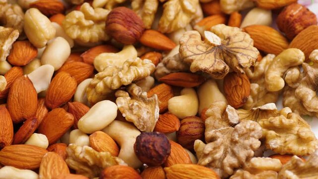Assorted whole nuts close up including hazelnuts, almonds, walnuts and cashews. Healthy superfood mix for wellness and balanced diet