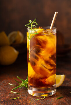 Iced tea or cocktail with ice, rosemary and lemon slices.