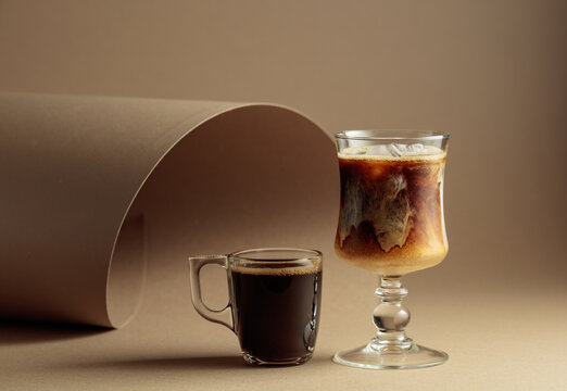 Black coffee and iced coffee cocktail on a beige background.