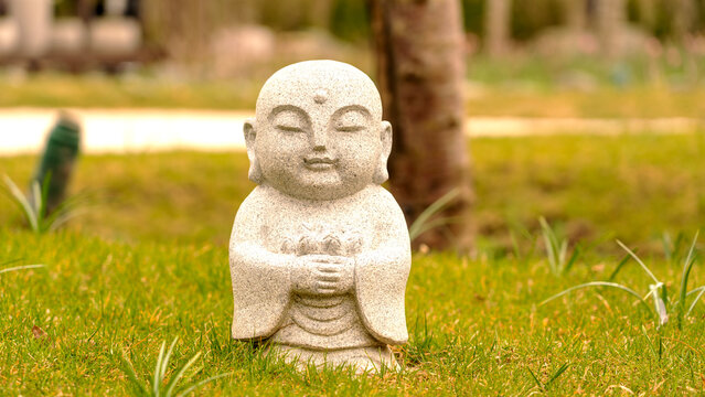 Stone statue sits peacefully on green grass