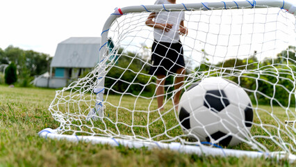 Child stands near goal, ready to kick ball © I
