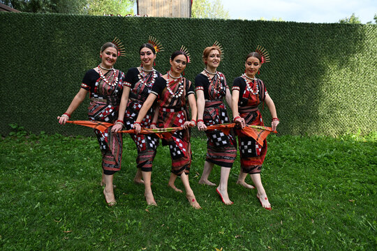 Five female dancers in colorful costumes dancing Indian dances in the park