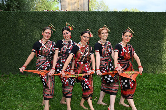 Five female dancers in colorful costumes dancing Indian dances in the park