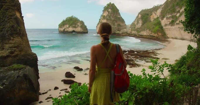 Woman looks out over the dramatic coastal landscape of Diamond Beach in Nusa Penida Bali