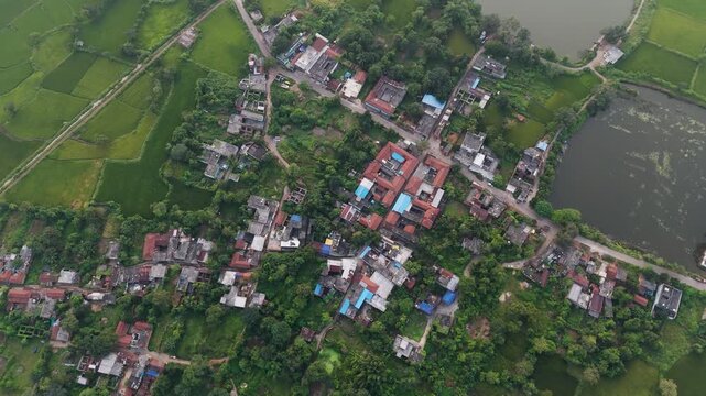 Aerial green village view, Rural farmland drone shot, Countryside houses top view, Village landscape with lake stock video.