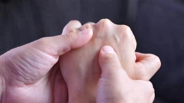 Therapist hands performing reflexology massage on a person palm back to relieve tension and pain